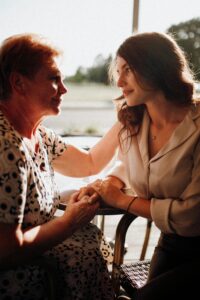 A touching moment depicting the bond between mother and daughter holding hands indoors.