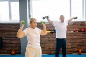 Elderly man and woman workout with dumbbells promoting healthy lifestyle and fitness.