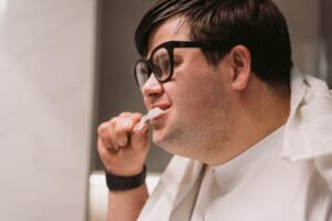 Adult man brushing his teeth, promoting daily oral health and hygiene habits.