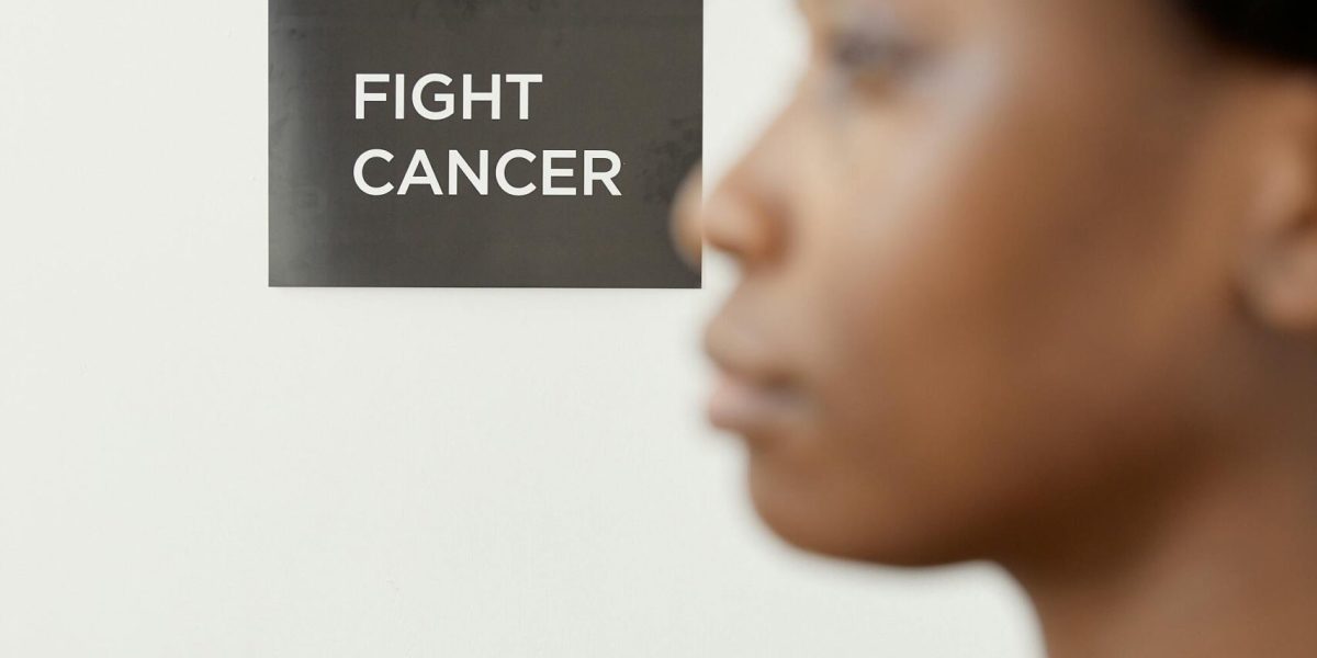 Side view of a woman with a 'Fight Cancer' message, promoting awareness.